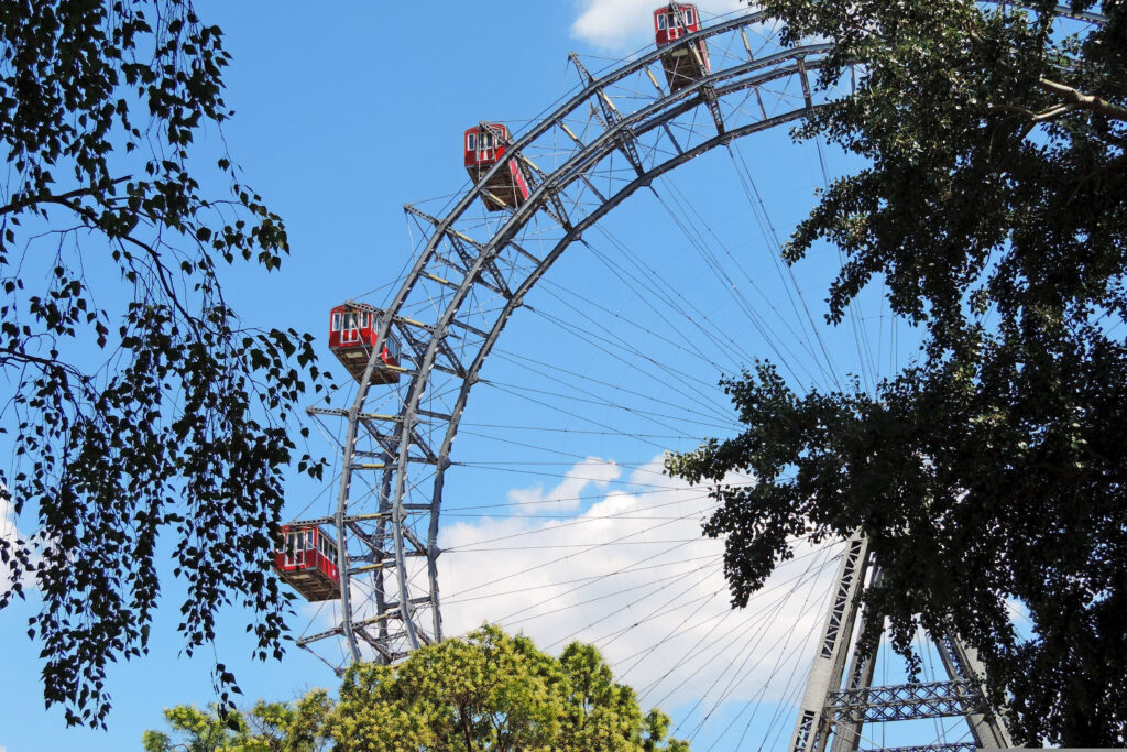 The Wiener Riesenrad Ferris wheel at the Vienna Prater seen among the trees on a clear summer day